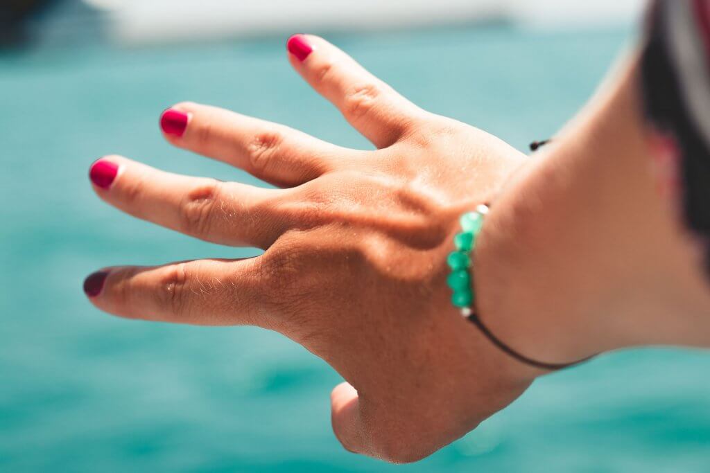 Hand zeigt aufs Meer